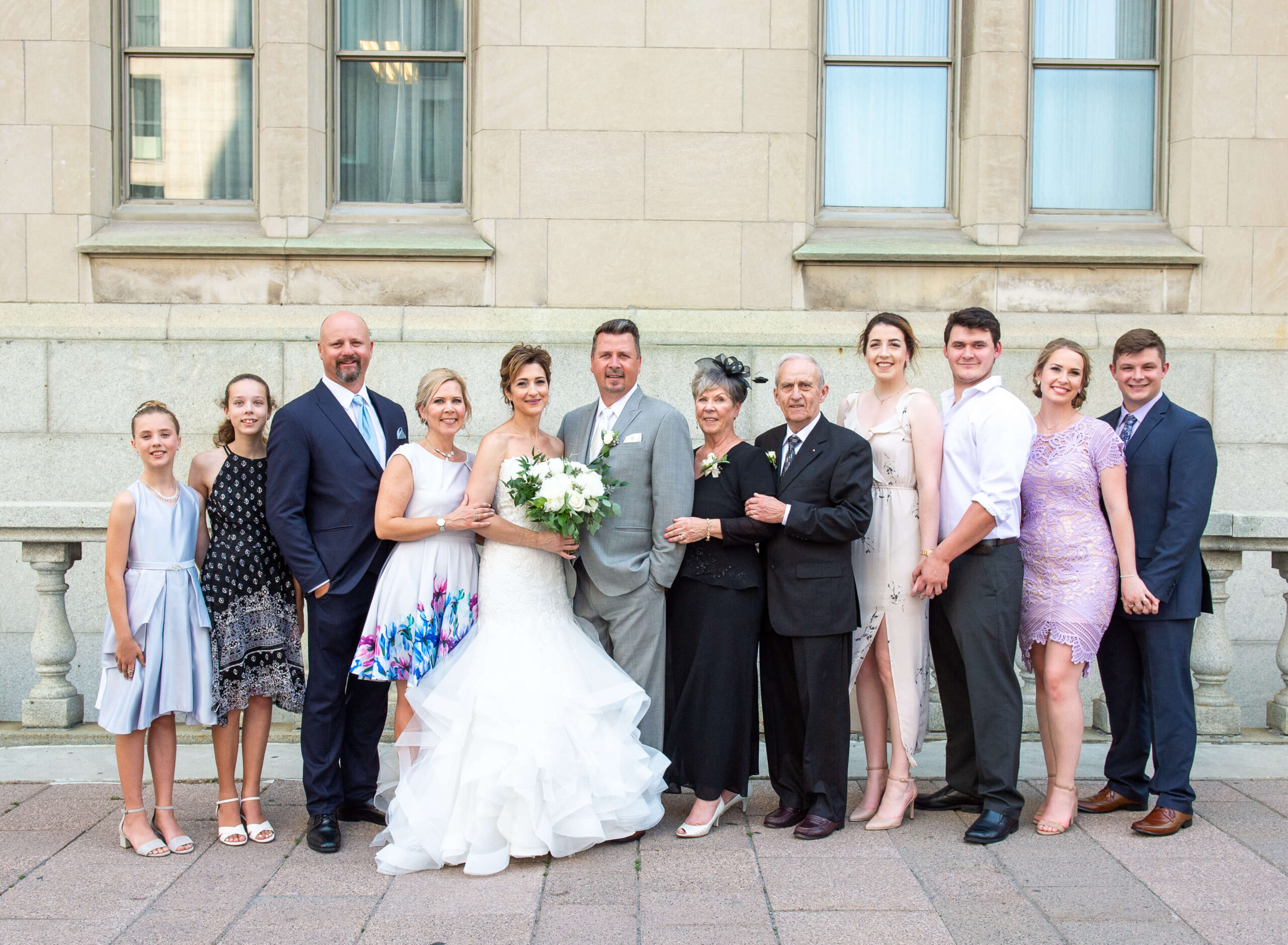 bride and groom with their family taken outside of the Chateau Laurier wedding venue