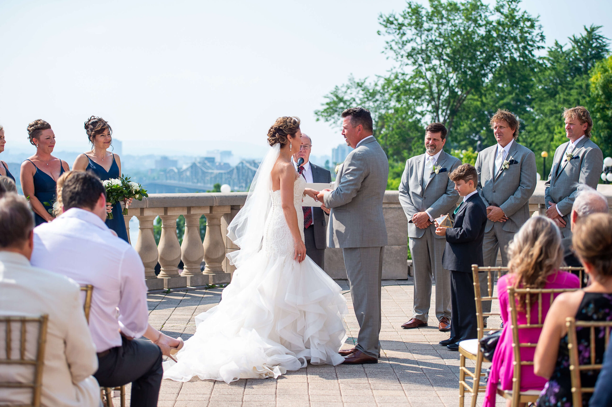 a bride and groom exchanging rings during their Chateau Laurier wedding ceremony on the terrace