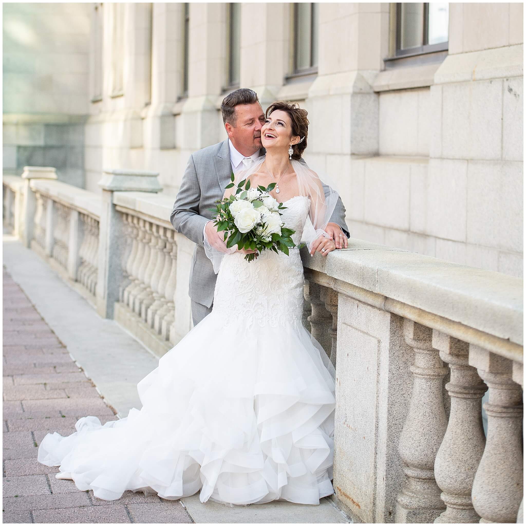 bride and groom laughing and embracing outside on the terrace after their Chateau Laurier wedding ceremony