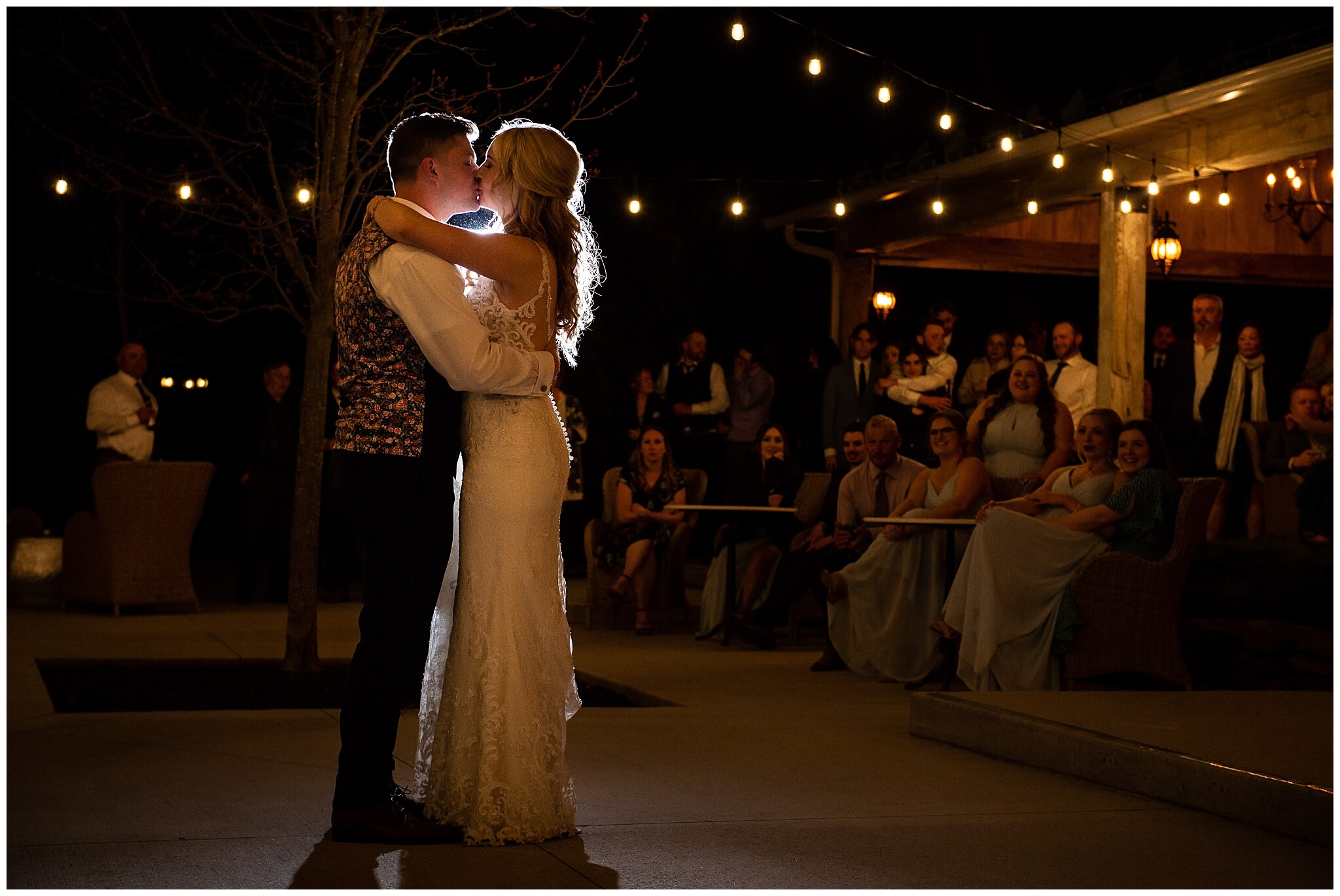 a bride and groom first dance outdoors under the Edison bulbs at Stonefields Estate in Ottawa