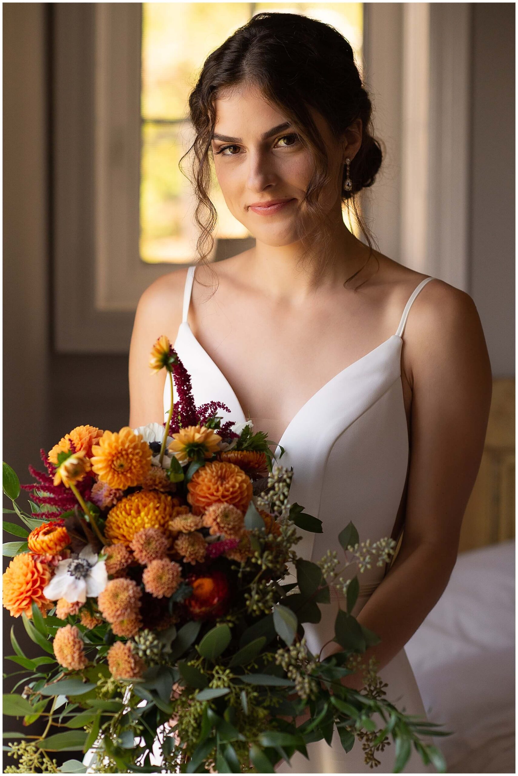 portrait of a bride holding a fall coloured bouquet as she gets ready for her Strathmere wedding in Ottawa