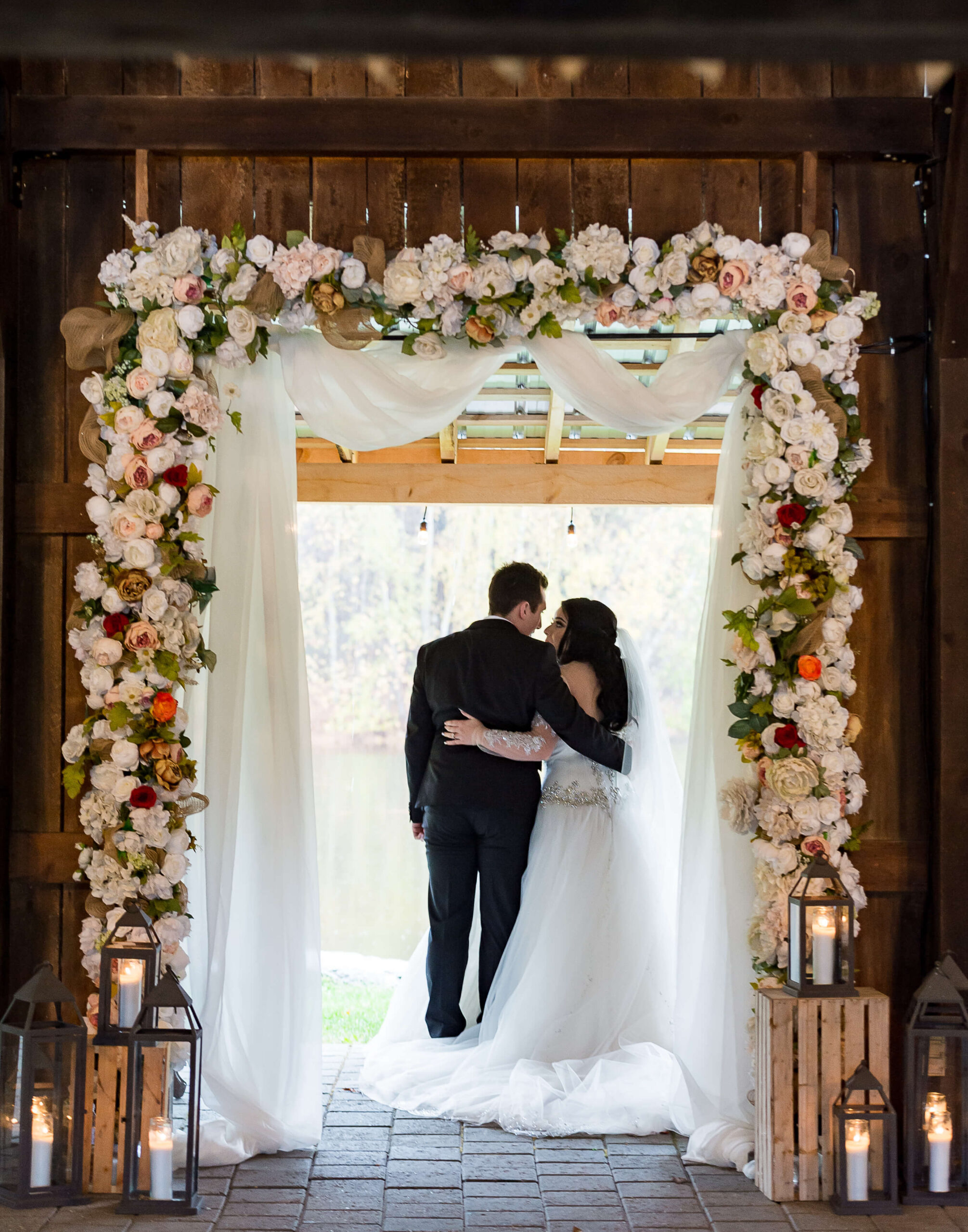 a bride and groom standing in the ceremony archway of the Pavilion of Bean Town Ranch