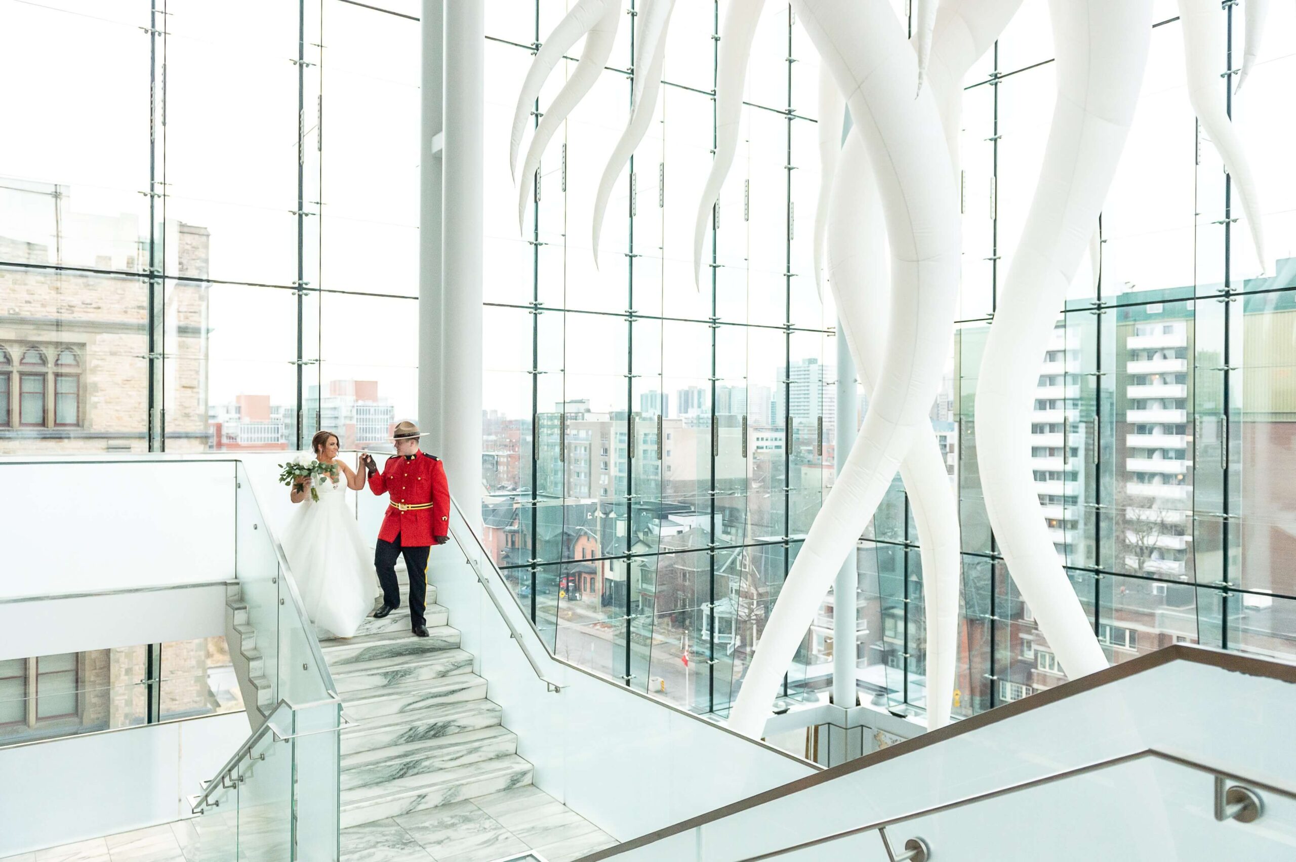 a bride and groom holding hands walking down the stairs of the Queen's Lantern in the Museum of Nature weddings venue