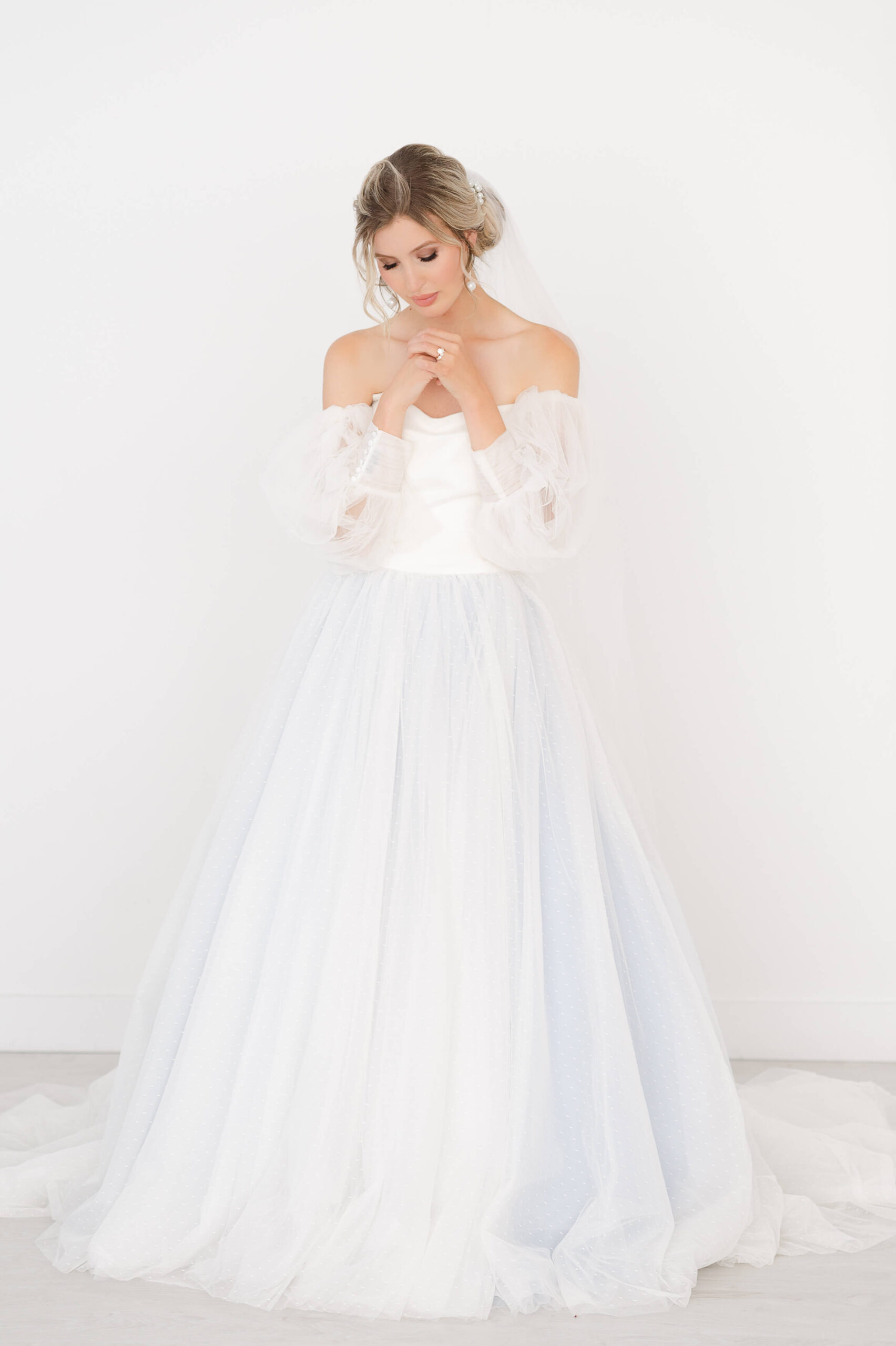 a bride in an Ottawa wedding dress that is off the shoulder and has a blue underlay