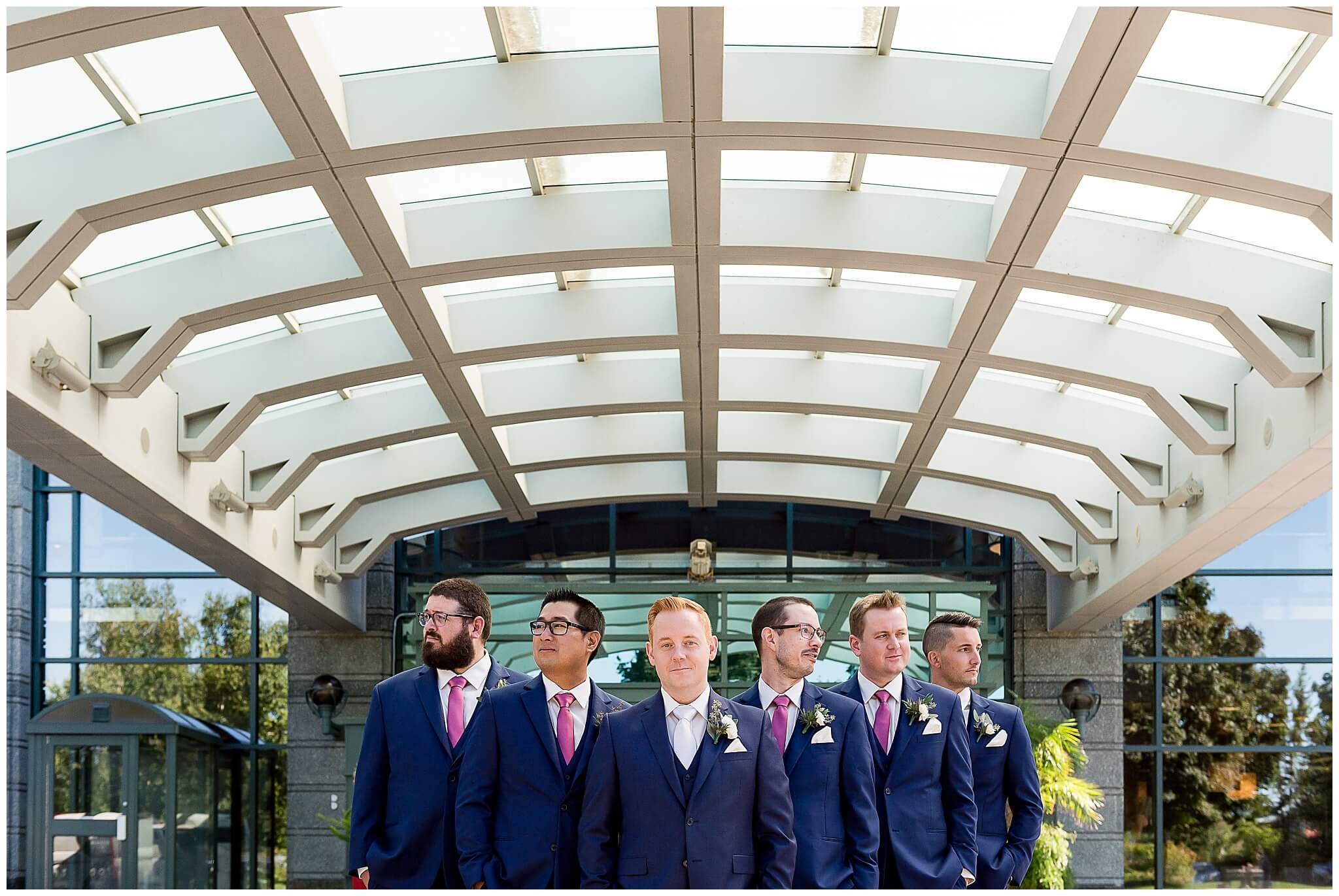 a groom and groomsmen in blue suits outside The Brookstreet Hotel
