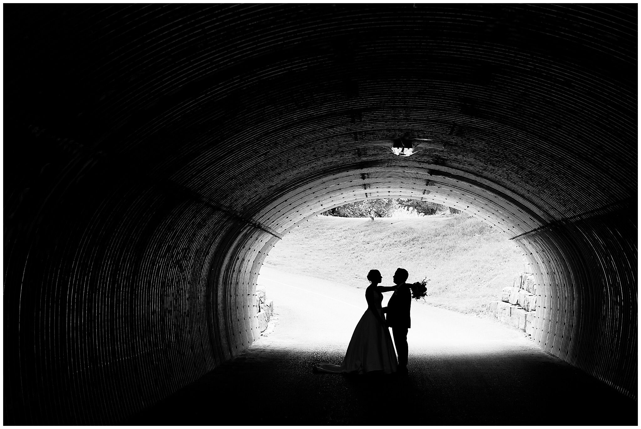 a black and white silhouette photo a bride and groom in the underpass tunnel of the Marshes wedding venue