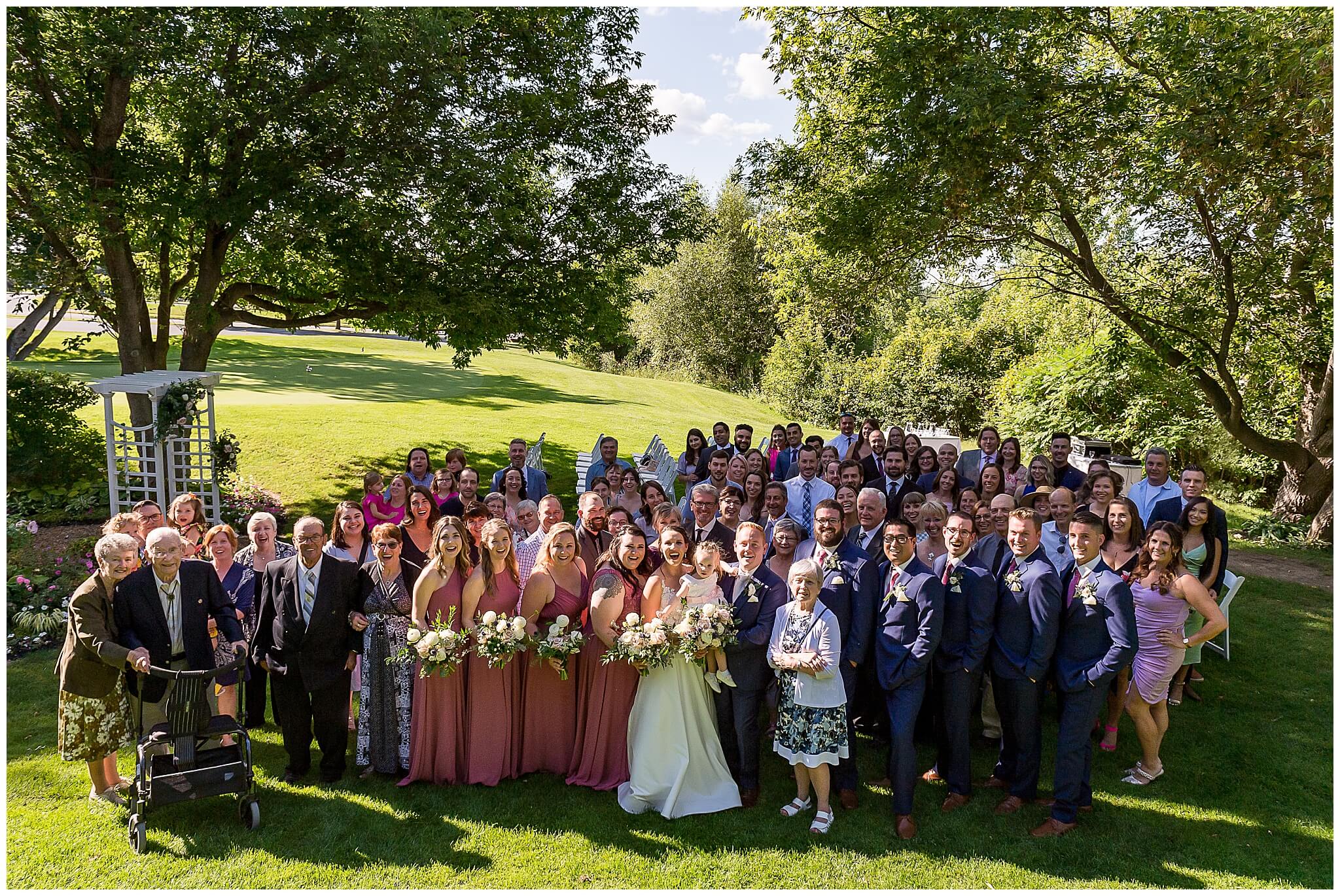 large group photo of a bride and groom and all their guests. Taken outdoors at The Marshes wedding venue