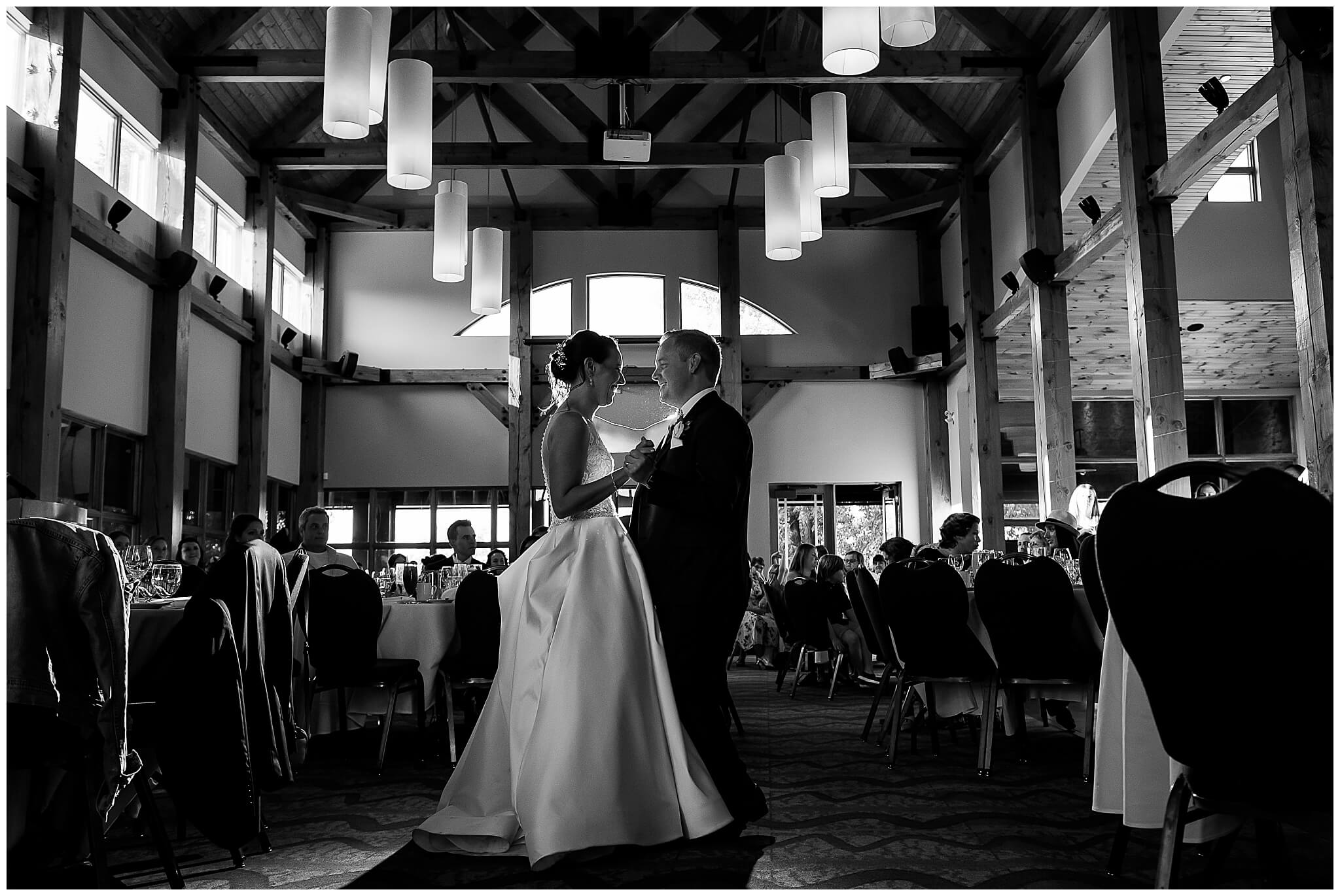 a black and white photo of a bride and groom dancing their first dance at the Marshes wedding venue