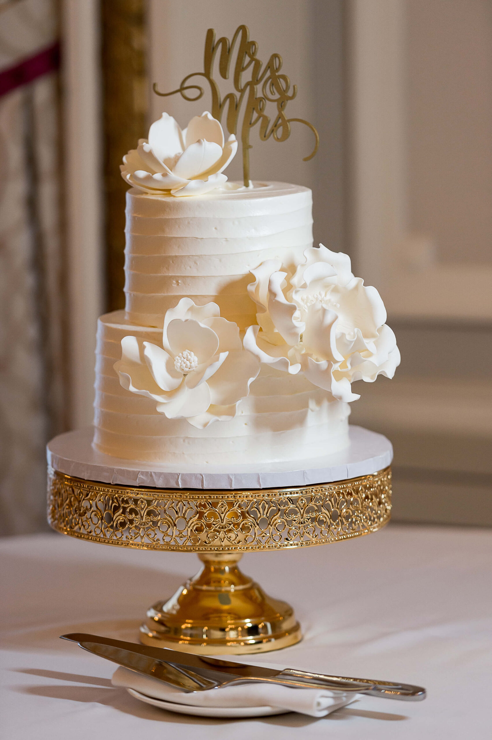 an elegant wedding cake in white with gold accents