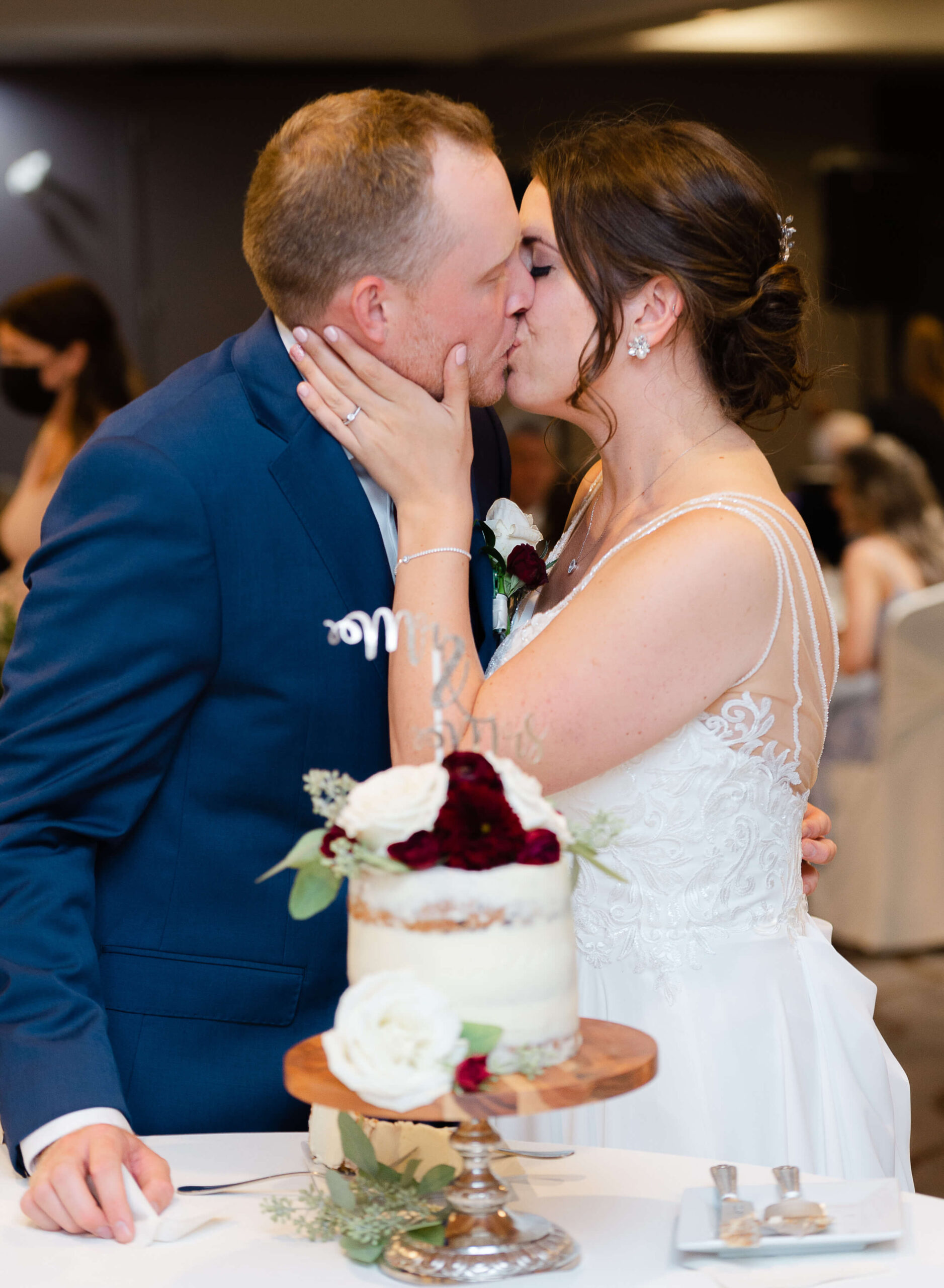 bride and groom kissing as they cut their cake at their wedding organized by Opportunity Knocks Events
