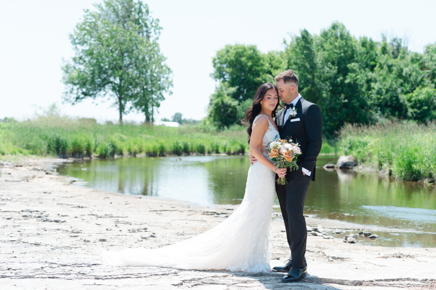 a bride and groom embracing on the Bleeks and Bergamot Wedding Venue riverside