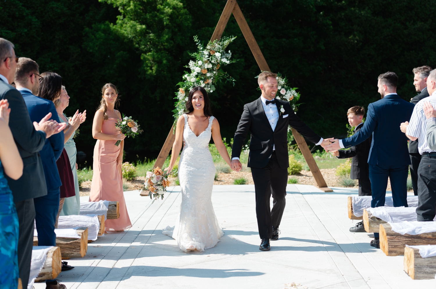 a bride and groom walking back up the aisle at their Bleeks and Bergamot Wedding and high fiving guests as they walk