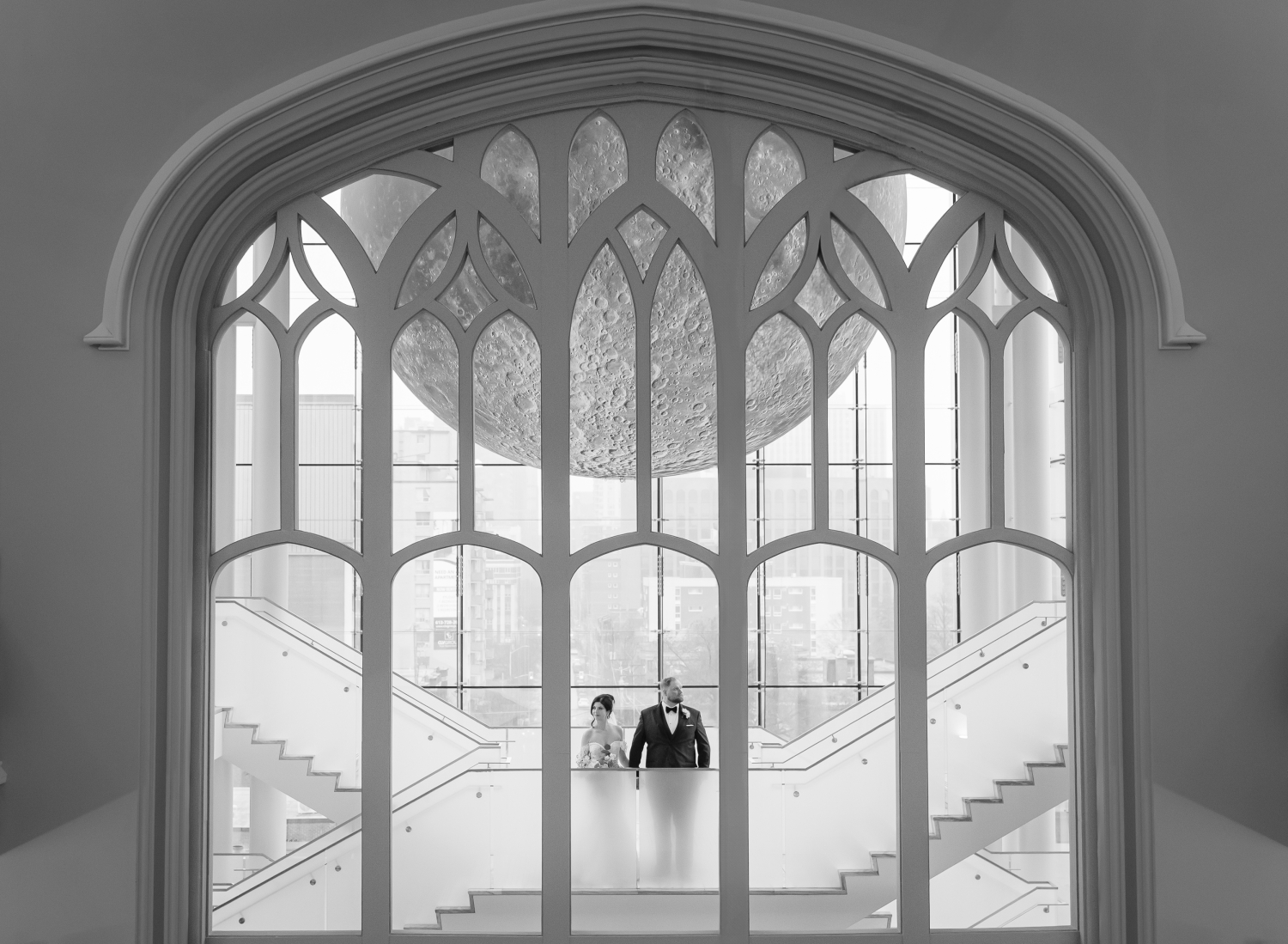 a black and white shoot through photo of a bride and groom in the Queen's Lantern as part of their Museum of Nature Wedding Photos