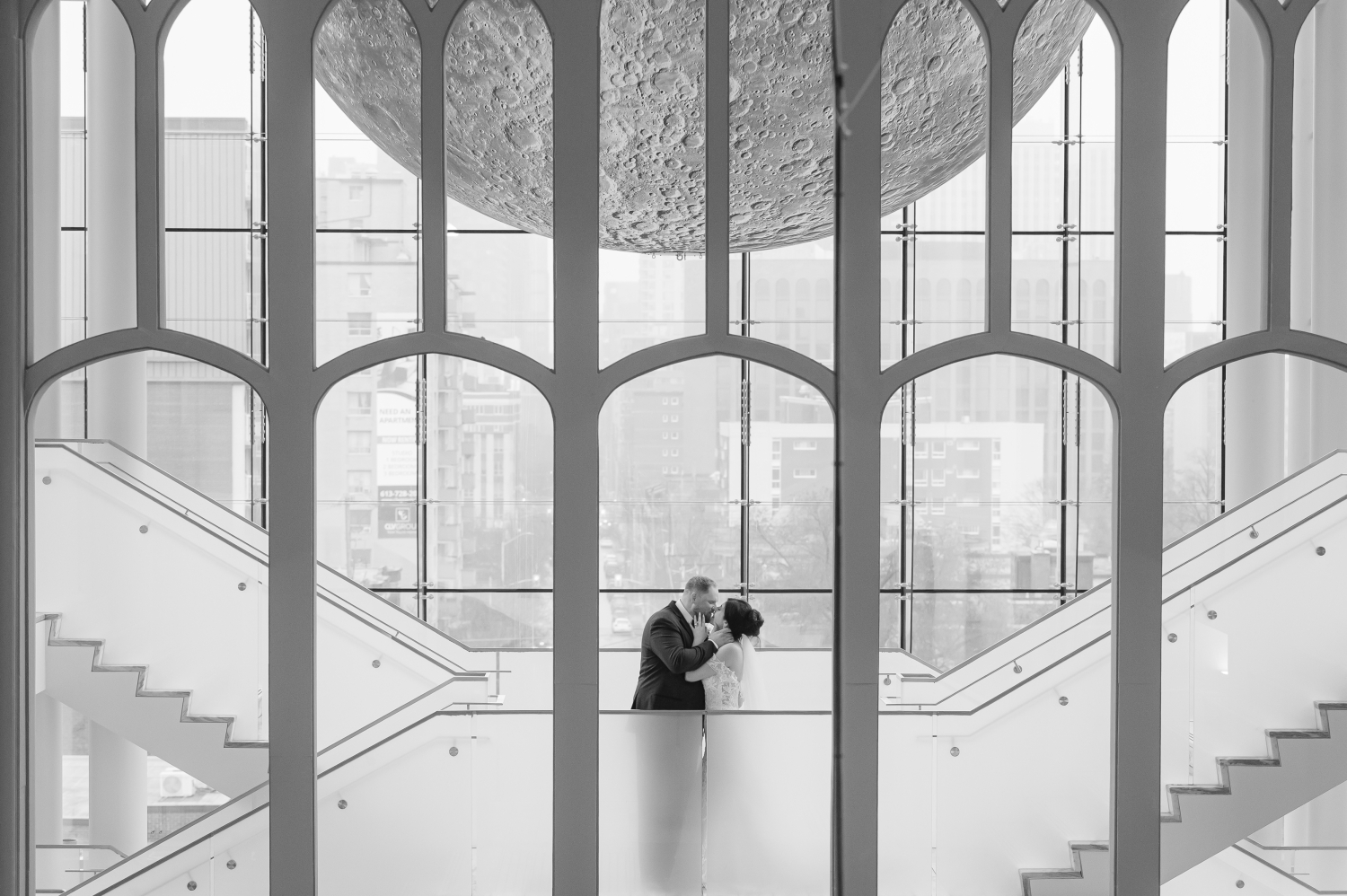 a black and white shoot through photo of a bride and groom kissing in the Queen's Lantern as part of their Museum of Nature Wedding Photos