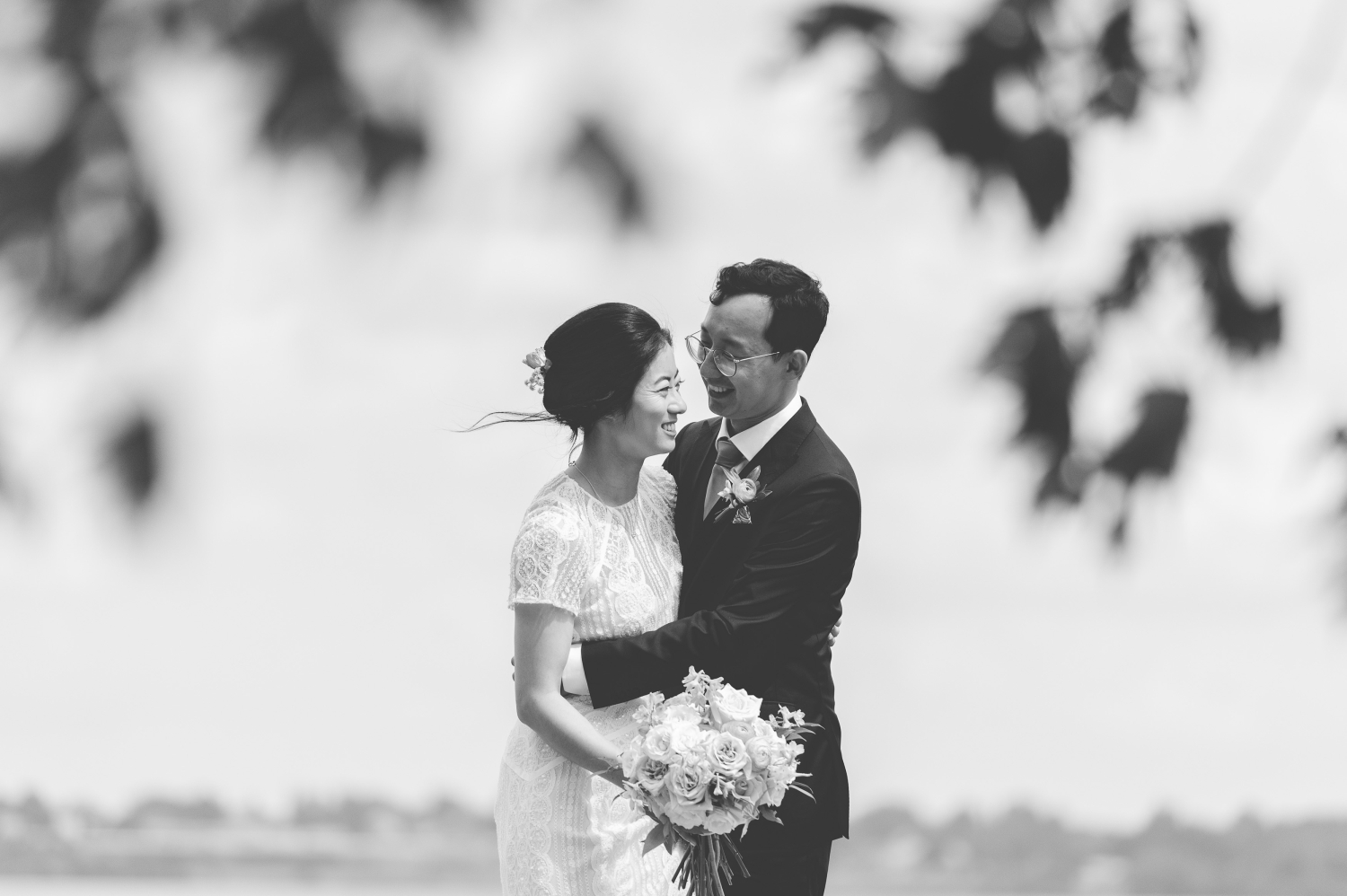 a black and white photo of a bride and groom laughing