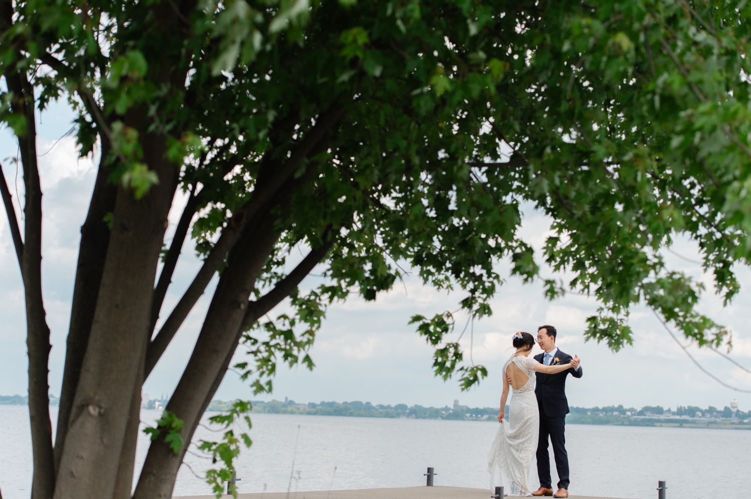 a bride and groom slow-dancing on the dock of their Ottawa backyard wedding property