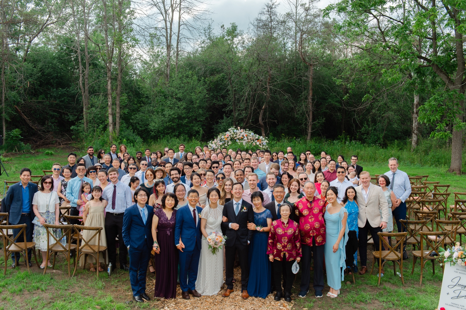 a group photo of a bride and groom and all their guests taken at the end of their Ottawa backyard wedding ceremony