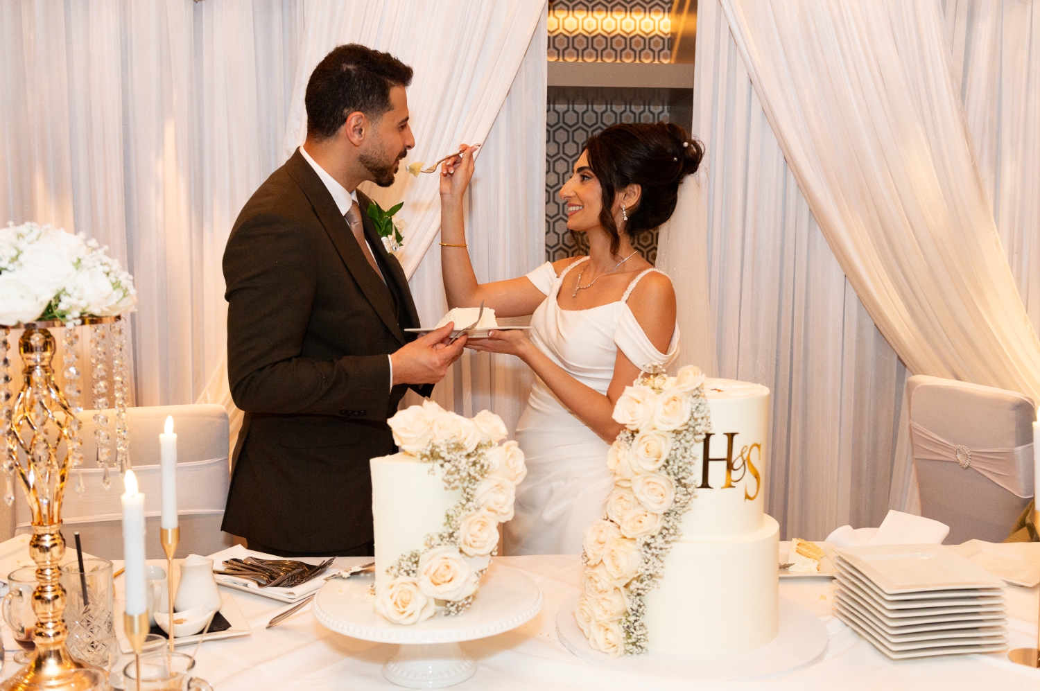 A bride feeds her groom a slice of wedding cake during her Restaurant 18 Wedding reception