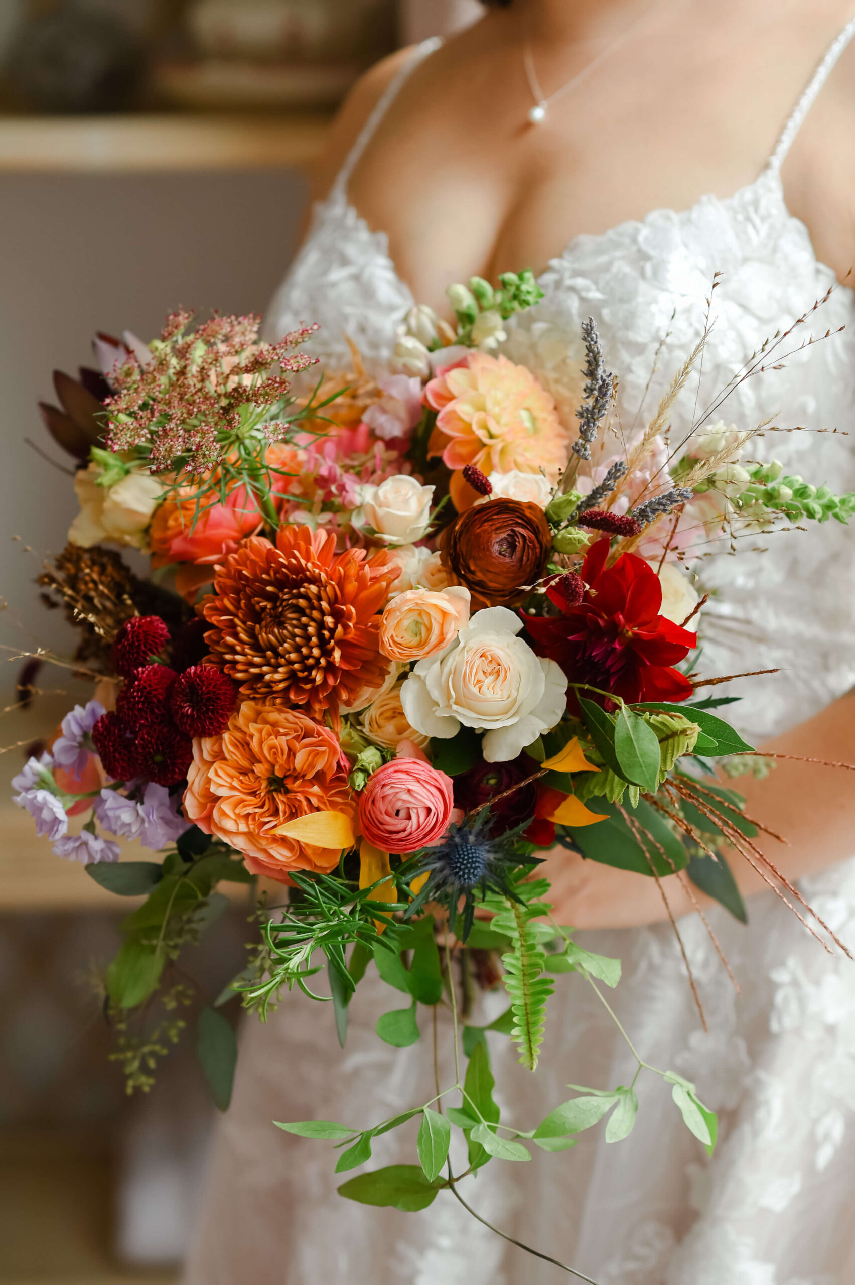 a closeup photo of a bride holding a fall coloured wedding bouquet. Captured in the Rose Room at the Maple and Rose wedding venue and luxury accommodations by JEMMAN Photography