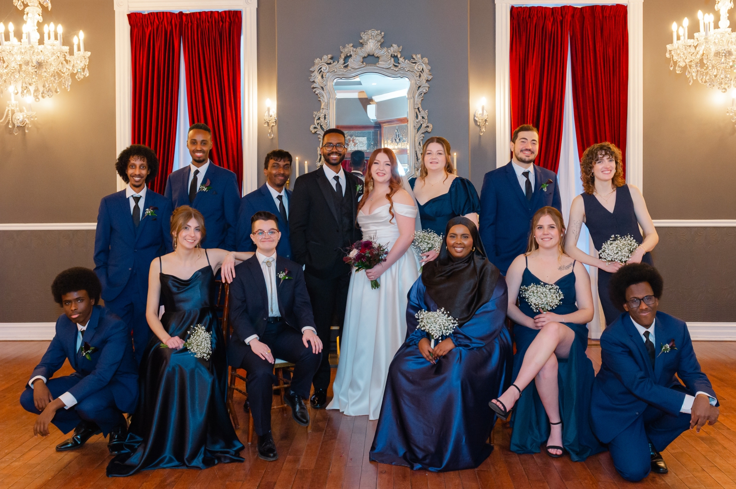 a group photo of a wedding party dressed in blue in the Carleton Room of the Grand Hotel Weddings. Captured by JEMMAN Photography