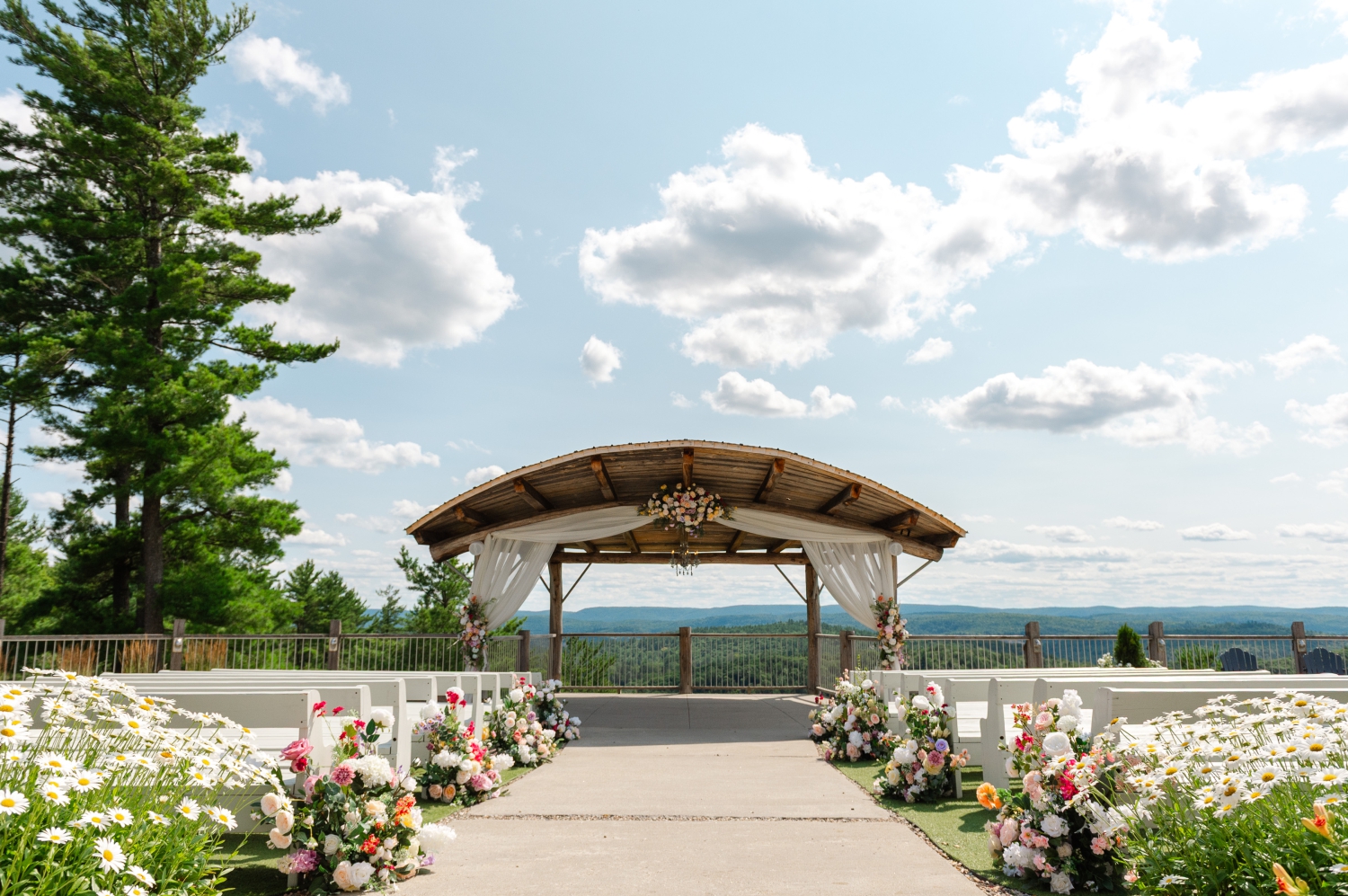 a photo of the outdoor ceremony space at the Ottawa outdoor wedding venue, Le Belvedere, decorated with florals lining the aisle and canopy. Captured by Ottawa wedding photographer JEMMAN Photography