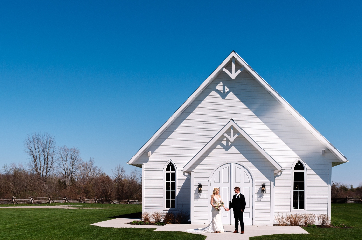 a bride and groom standing outside the Ceremony House of the Ottawa outdoor wedding venue, Stonefields Estate. Captured by JEMMAN Photography