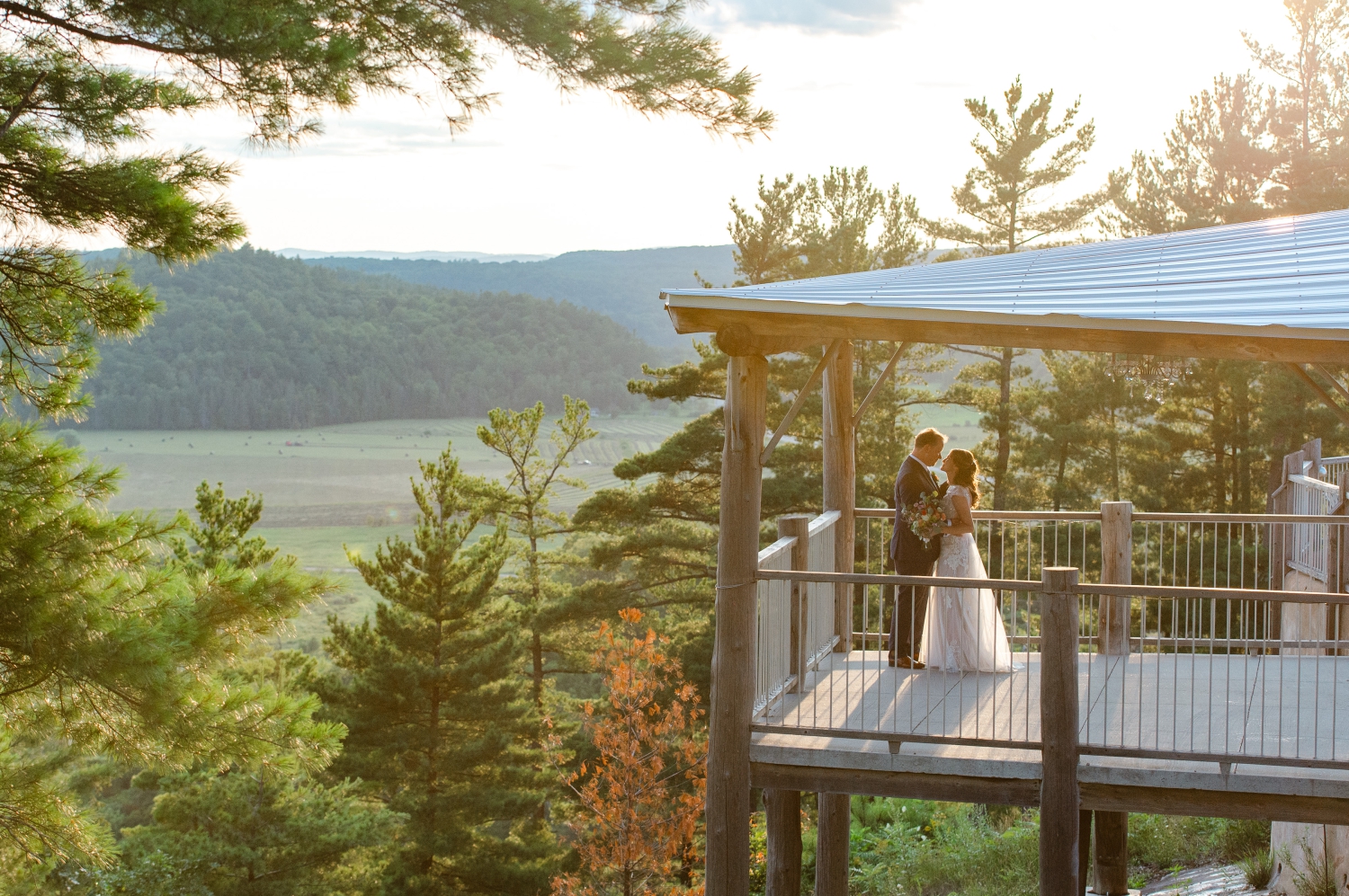 a photo of a bride and groom overlooking the Gatineau Hills during sunset. Captured on the deck of the Ottawa outdoor wedding venue, Le Belvedere by JEMMAN Photography