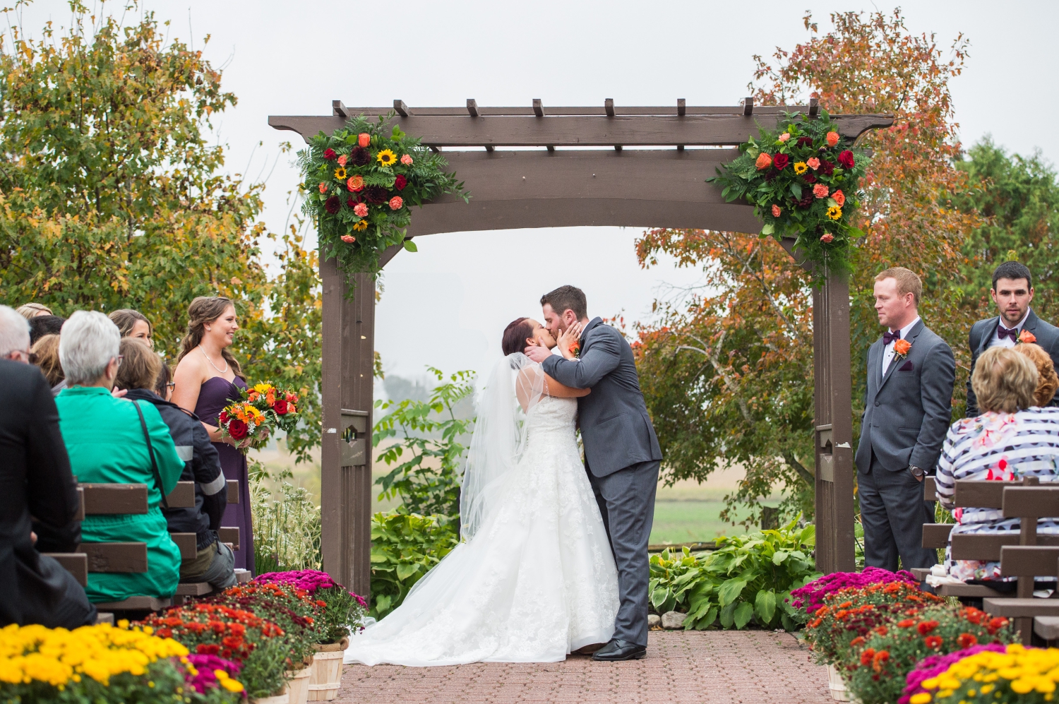 a photos showing a bride and groom's first kiss taken during their outdoor wedding at Strathmere Estates. Captured by Ottawa wedding photographer JEMMAN Photography
