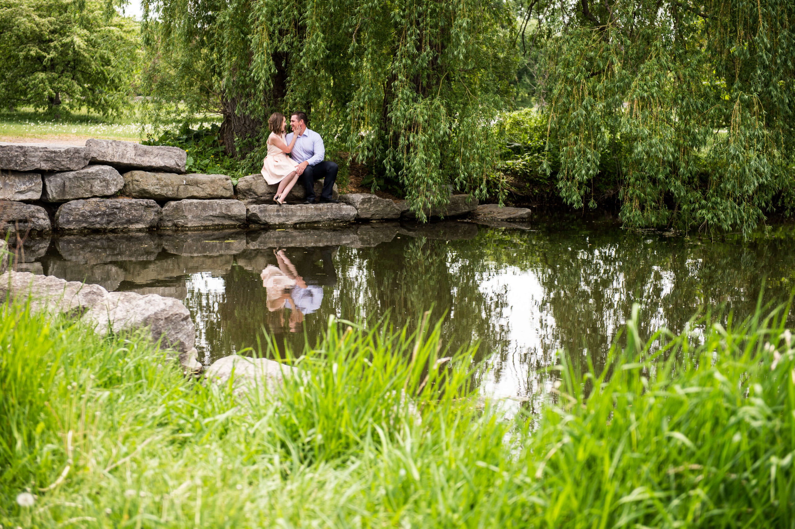 a male and female sitting on rocks at the Arboretum, one of the best places to propose in Ottawa. Captured by JEMMAN Photography