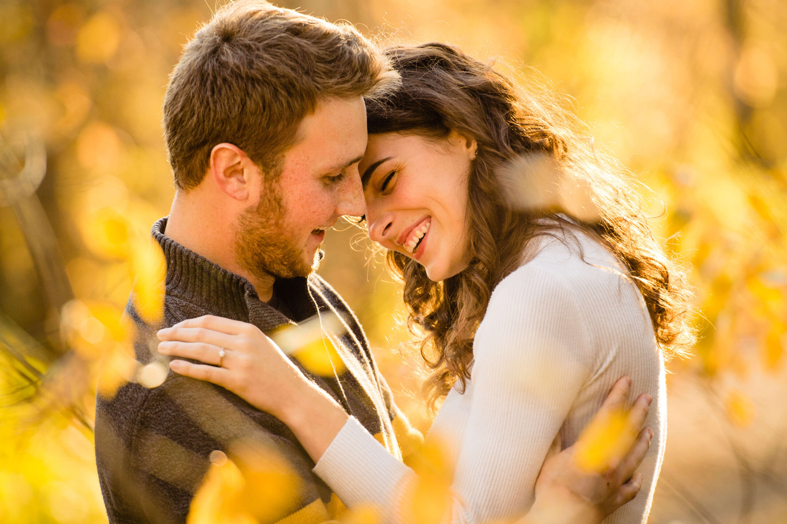 a female with brown curly hair smiling and laughing after being proposed to in one of the best places in Ottawa. Captured by JEMMAN Photography