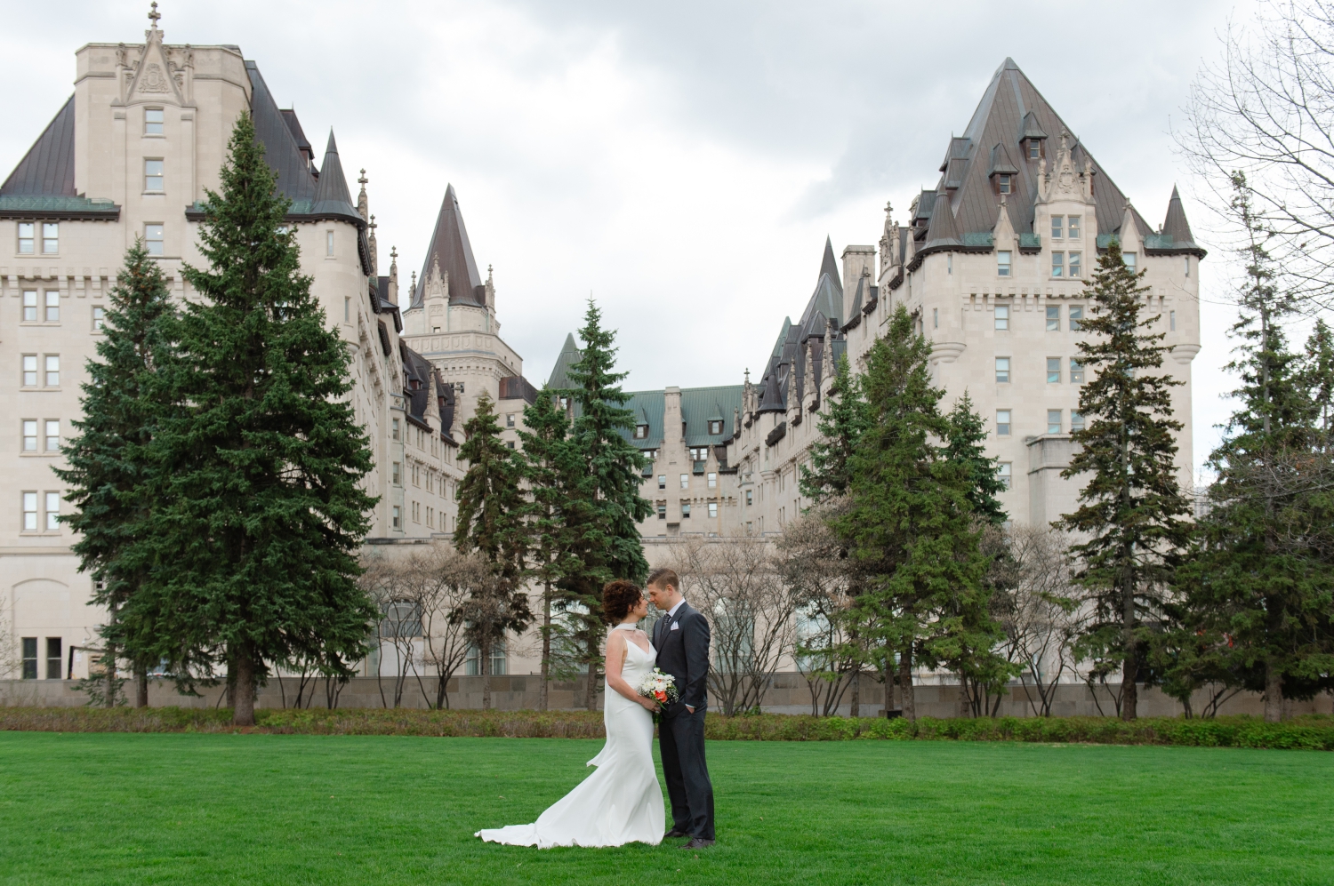 a bride and groom looking at each other adoringly. Taken with the Chateau Laurier in the background as part of their Starling Ottawa wedding photography